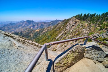 Sequoia Ulusal Parkı 'ndaki Moro Rock patikasından geniş bir manzara. Kaliforniya' da engebeli granit çıkıntısı var. Metal korkuluklar ve açık güneşli bir günde ormanlık dağları süpürüyor..