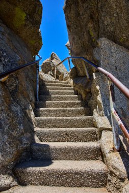 Güneş ışığı basamakları Sequoia Ulusal Parkı 'ndaki Moro Rock patikası boyunca uzanan engebeli granit kayaların arasından yukarı doğru esiyor. Kaliforniya macerayı ve doğal manzaraların güzelliğini çağrıştırıyor..