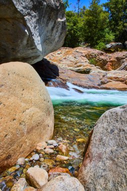 Büyük granit kayalar, Sequoia Ulusal Parkı 'ndaki temiz akan Orta Çatal Nehri' ni canlı kayalar ve yeşil ormanlarla çevreleyerek ferahlatıcı bir doğal manzara oluşturuyor..
