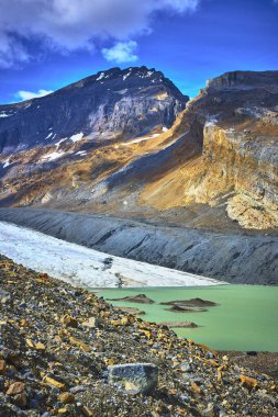 Jasper Kanada 'daki engebeli dağlarla tezat oluşturan buzul ve turkuaz eriyen su havuzu Athabasca Buzulu manzarasının el değmemiş güzelliğini vurgulayan çarpıcı bir doğal manzara yaratıyor..