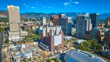 Salt Lake City şehir merkezinde modern gökdelenler ve Wasatch dağlarıyla çevrili Salt Lake Utah Tapınağı 'nın havadan görüntüsü.