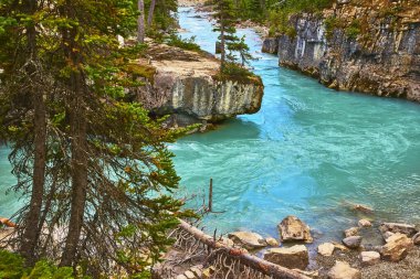 Kristal berrak su Kootenay Kanada 'daki kayalık Mermer Kanyon' da esiyor. Etrafında hiç bitmeyen yeşil ağaçlar ve dramatik uçurumlar var. Canlı ve ferahlatıcı bir doğal manzara yaratıyor..