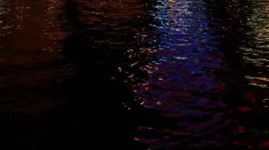 Las Vegas 'taki Strip' ten canlı şehir ışıkları dalgalanır ve durgun bir gecede karanlık sularda yansıyarak şehir atmosferinin hareketini ve renkli yansımalarını yakalar..