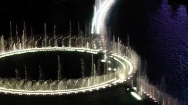 Hava görüntüsü Las Vegas Strip Fıskiyesi gösterisini gece kareograflı su jetleri ile sabit bir manzarayla aydınlatır. Nevada 'da gece hayatı ve eğlence gösterilir.