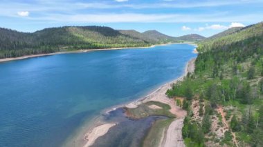 Utah 'ın Duck Creek Köyü yakınlarındaki bir dağ gölünün üzerinden uçan canlı mavi su kıvrımlı kıyı şeridi ve yemyeşil orman pürüzsüz bir şekilde yakalanır. Yolculuk ve açık hava için mükemmeldir.