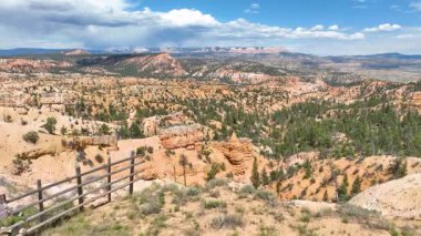 Hava kaidesi görüntüsü Bryce Kanyonu 'nun dramatik kırmızı kaya oluşumları ve yoğun çam ormanı altında parlak mavi gökyüzünün altında geniş Utah manzarasını ve macera duygusunu yakaladığını gösteriyor..