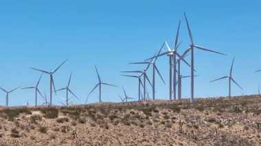 Mojave Çölü Kaliforniya 'sında rüzgar türbinlerinin havadan çekilmiş görüntüsü. Kamera, yenilenebilir enerji ve kurak gökyüzü altında berrak ve berrak manzarayı vurguluyor..
