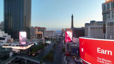 Nevada 'daki Las Vegas Bulvarı' nın üzerinde havadan çekim süzülürken, sabahın erken saatlerinde dinamik bir şehir seyahati sahnesi için palmiyeli ünlü kumarhaneler ve canlı reklam panoları sergileniyor..