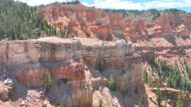 Utah 'taki dramatik kızıl kaya kanyonu uçurumları ve çam ormanlarının üzerinden geçen hava uçuşu Cedar Highlands ve Palavracı Dağı' nı canlı gün ışığında hareketlendiriyor..