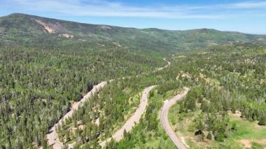 Utah Cedar Highlands 'daki yemyeşil orman ve dağ arazisi boyunca dolambaçlı bir Cedar Kanyon Yolu' nun üzerinden uçmak geniş manzaralı ve hareket hissi seyahat ve macera temaları için mükemmel..