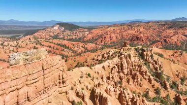 Dixie Ormanı Utah 'taki canlı kırmızı kabadayıların ve kanyon sırtlarının üzerinden uçan havadan geniş manzaralar ve yemyeşil çam ağaçları muhteşem doğal güzelliklerle dinamik bir çekim yaratıyor..