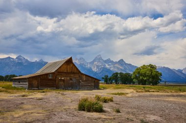 Tarihsel TA Moulton Barn Wyoming 'deki Mormon Row' da görkemli Grand Teton dağ sırası ve açık çayırlarıyla klasik bir Birleşik Devletler batı manzarası yaratıyor..