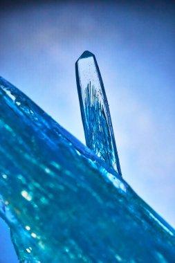 Mavi kristalin çarpıcı bir makro görüntüsü karmaşık ayrıntıları ve titreşen dokuyu sakin bir ortamda ortaya çıkarır. Havalı tonlar ve soyut formlar, entelektüellik ve yenilik duygusunu çağrıştırıyor.