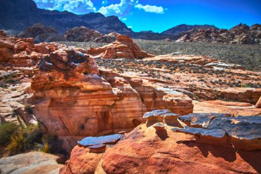 Canlı kızıl kaya oluşumları ve engebeli çöl arazisi Nevadas Çamurlu Dağ Bölgesi 'nin özünü yakalıyor. Güneş ışığı kumtaşı, seyrek bitki örtüsü ve uzak tepeler Moapa 'nın doğal güzelliğini çağrıştırıyor.