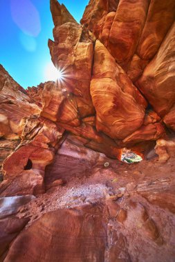 Güneş ışığı Nevada 'daki Bitter Springs Patikası boyunca canlı bir kumtaşı kemerinin içinden fışkırıyor. Kızıl kaya oluşumları ve çöl dokuları macera ve Moapa Vadisi ve Çamur Vadisi 'nin vahşi ruhunu çağrıştırıyor.