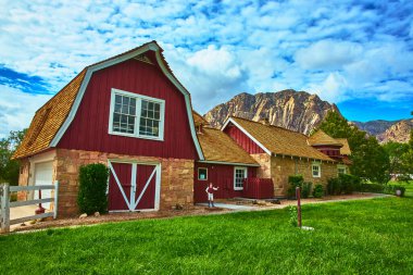 Kırmızı ve bronz taş işçilikli bir çiftlik binası Nevada 'daki Red Rock Kanyonu' nun dramatik uçurumlarının önünde duruyor. Bereketli yeşil çimenler ve canlı gökyüzü Las Vegas 'ın davetkar kırsal atmosferini artırıyor..