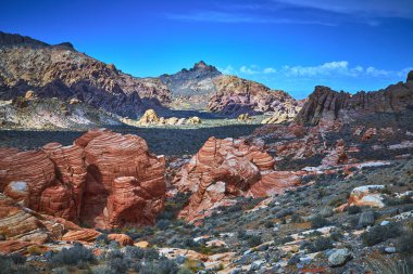 Canlı kırmızı kumtaşı oluşumları ve engebeli arazi Muddy Dağı ve Moapa Vadisi yakınlarındaki Nevada Çölü 'ne hakim. Dramatik dokular ve parlak renkler Saklı Vadi 'nin eşsiz güzelliğini çağrıştırıyor.