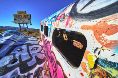 Beatty yakınlarındaki Nevada çölünde Angels Ladies imzalı bir duvar yazısı duruyor. Canlı sokak sanatı, uçağın gövdesini açık mavi bir gökyüzünün altında renklendirir ve Birleşik 'in eşsiz bir parçasını yakalar.