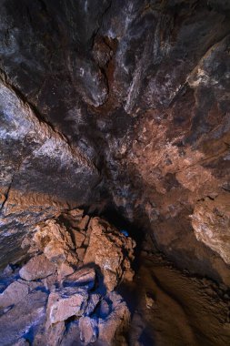 Engebeli volkanik kayalar ve desenli mağara tavanı Kelso California yakınlarındaki Mojave lav kanalında gizemli bir sahne oluşturuyor. İnce mavi röfleler doğal yeraltı manzarasına entrika ekler..
