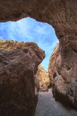 Yüksek kaya duvarları Arizona 'daki Ürkünç Kanyon' da dramatik bir yol yaratır. Canlı mavi gökyüzü ve dokulu taş bu eşsiz Güneybatı kanyonunun maceralı havasını yakalıyor.