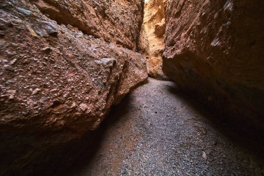 Güneş ışığı, Arizona 'daki dar bir delik kanyonuna sarmal çakıl yolunun üstündeki dokulu kaya duvar kulesi gibi süzülür. Sahne macerayı çağrıştırıyor ve Ürkütücü Kanyon 'un benzersiz oluşumlarını vurguluyor..