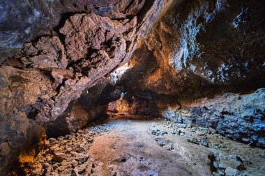 Doğal ışık, Kelso California yakınlarındaki Mojave Çölü 'nde bulunan lav kanalına akar. Engebeli volkanik kaya oluşumlarını ve dramatik yeraltı manzarasının dokulu mağara duvarlarını vurgular..