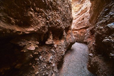 Güneş ışığı Arizona 'daki Ürkünç Kanyon' un dar yolunu aydınlatıyor. Engebeli kaya duvarları dramatik ve maceralı bir atmosfer yaratıyor. Yuvarlak kanyon geçidi havayı canlandırır.