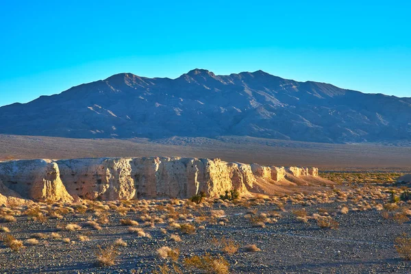 Altın saat ışığı, Las Vegas Nevada yakınlarındaki Tule Springs Fosil Yatağı 'nın engebeli uçurumlarını ve kurak çöl tabanını aydınlatmakta..