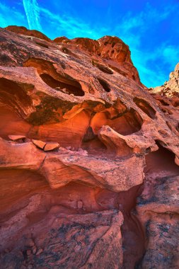 Las Vegas Nevada yakınlarındaki Ateş Kasesi 'nde parlak mavi gökyüzüne karşı eşsiz aşınmış oyukları olan canlı kırmızı kumtaşı oluşumları kurulmuştur. Sert kaya dokuları ve dramatik şekiller bir his yaratır.