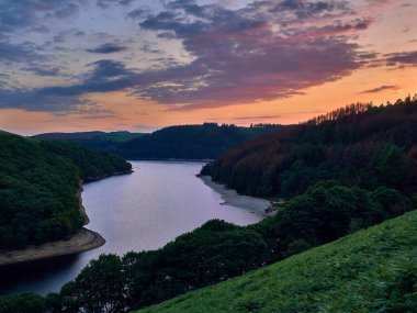 Llyn Brianne Barajı, Sunset 'te. Towy nehrinin akışını düzenlemek için inşa edilen ve Galler 'in ortasındaki Kambriyen Dağları' nda yer alan, yürüyüşçüler, balıkçılar, dağ bisikletçileri, kuş gözlemcileri ve at binicileri için popüler bir turistik merkezdir..      