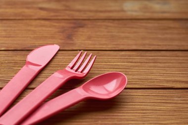 Tahtadaki plastikten yapılmış ekolojik çatal bıçak takımı. Çevre koruma kavramı