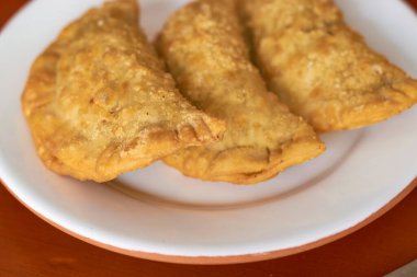 Tabağınızda taze yapılmış üç böreğin yakın çekimi. Arjantin gastronomi kavramı.