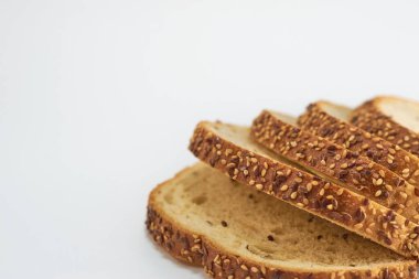 Beyaz arka planda dilimlenmiş tam buğday ekmeği..