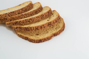 Beyaz arka planda dilimlenmiş tam buğday ekmeği..