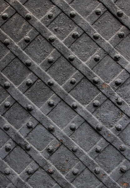 Detail of wrought iron door with a metal plate twisted and sculpted nails