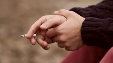 Adamın elinde bir sigara ile.