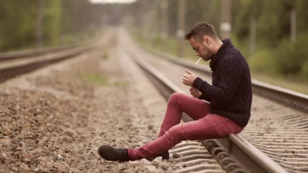 Man smokes on the rails. — Stock Video