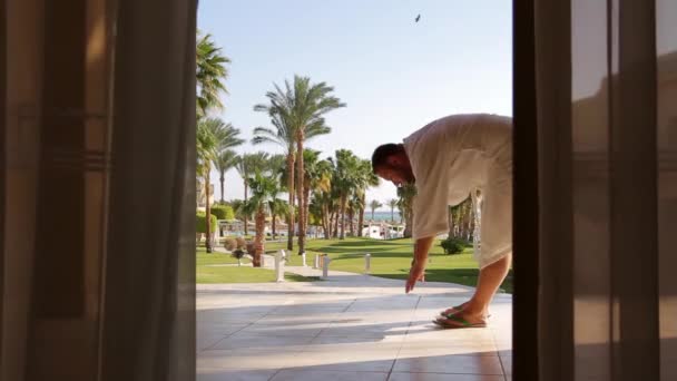 Man White Robe Terrace Overlooking Sea Doing Warm Bends Waving — Stock Video