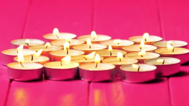 Kleine Brandende Kaarsen Die Een Groep Een Roze Achtergrond Worden — Stockvideo