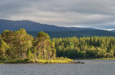 Dağ yabanda bir nehrin üzerinde güneş batıyor. Jamtland, İsveç.
