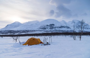 Ünlü dağ Ahkka 'nın yanında bir kış sabahı çadır. Laponya, İsveç.