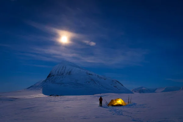 Nijak Dağı 'nın yakınındaki karlı arazide çadırının yanında bir adam, Sarek Dağı' nda. Laponya. İsveç.