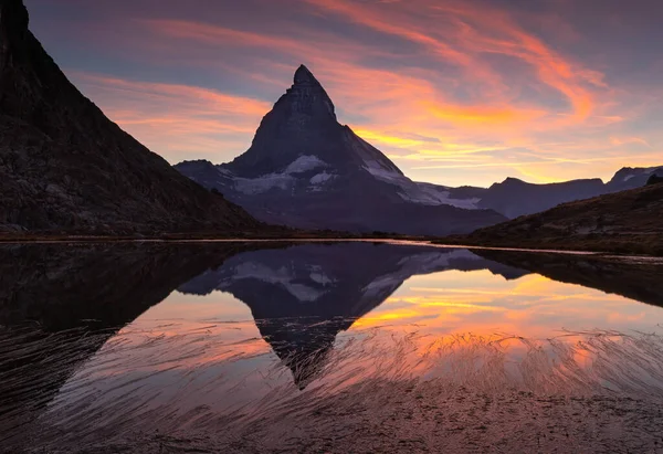 Sunset at the Riffelsee, with the famous Matterhorn reflected in the lake.