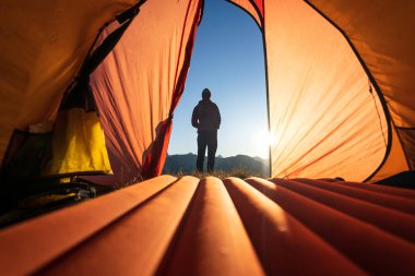 Relaxing in front of the tent in the mountains during a summers sunrise.