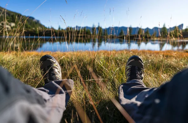Legs of a hiker relaxing and enjoying the view in the mountains.