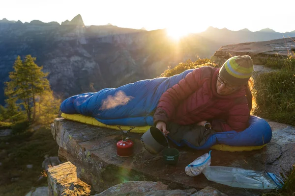 Dağlarda güzel bir sabah, ordugahından kahvaltı hazırlayan bir kadın..
