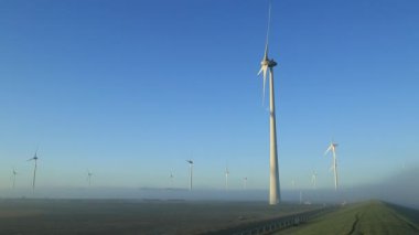 Rüzgâr türbini sisli bir sabahta sürdürülebilir enerji üretiyor.