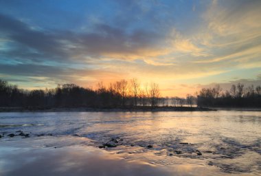Fransa 'nın Lyon kenti yakınlarındaki Rhone nehrinde huzur ve renkli gün doğumu.