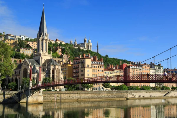 Saint Georges köprüsündeki yayalar ve Lyon, Fransa 'daki Aziz Georges kilisesi..