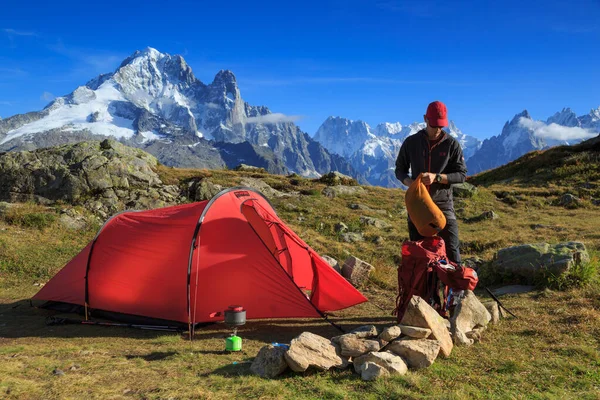 Yürüyüşçü ve kırmızı çadırı Chamonix, Fransa yakınlarındaki dağlarda..